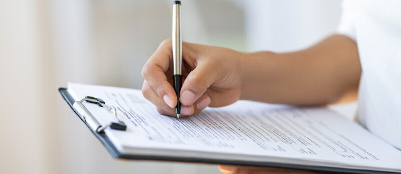 Holding clipboard and a pen in office 2026 Blog - Inspection importance